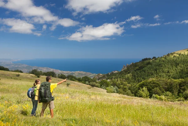 Couple avec sacs à dos sur terrain vert — Photo