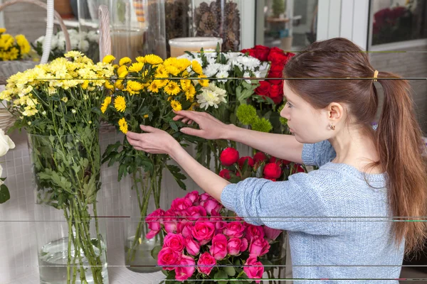 Mujer cuidando flores en la tienda — Foto de Stock