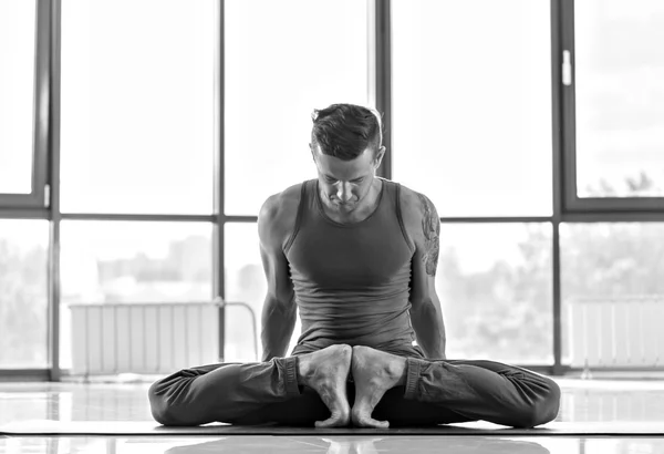 Спортивный мускулистый юноша тренируется, йога — стоковое фото