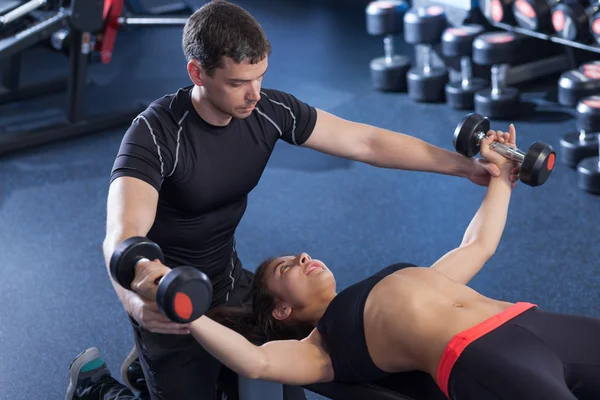 Fitness woman and personal trainer in gym — Stock Photo, Image