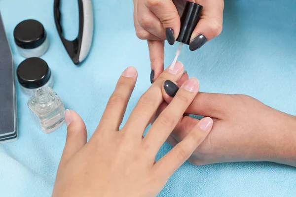Beautician polishing female nails — Stock Photo, Image