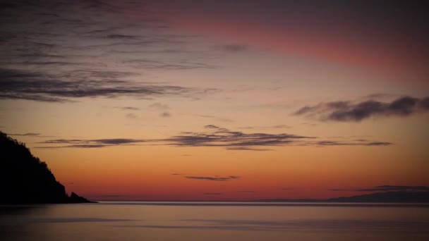 Clouds over a lake at sunrise, with brilliant colors. — Stock Video
