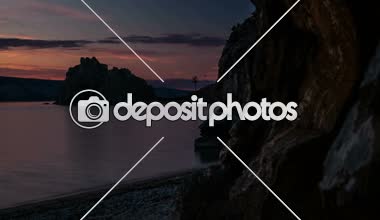 Göl kenarında kaya üzerinde gündoğumu. Zaman atlamalı