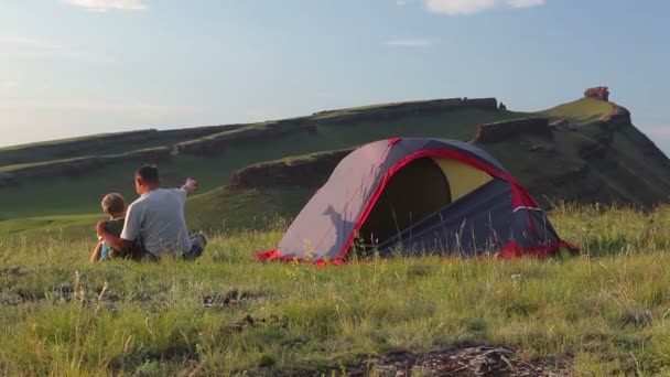 Padre con hijo descansa en un campamento en las montañas — Vídeo de stock