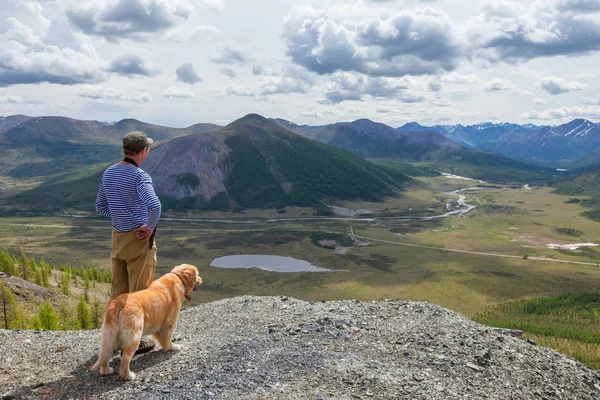 男と彼の犬は、山の景色を眺める — ストック写真