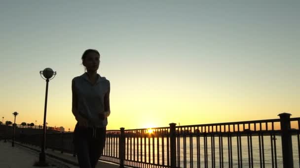Молодая женщина бегает на закате — стоковое видео