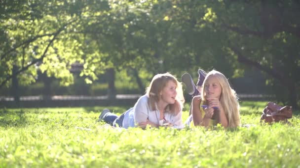 Feliz Adolescentes leyendo un libro al aire libre . — Vídeos de Stock