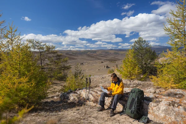 Backpacker ler mapa na viagem florestal enquanto descansa . — Fotografia de Stock