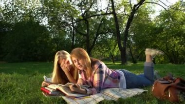 Mutlu Teenage Kız açık havada bir kitap okuma.