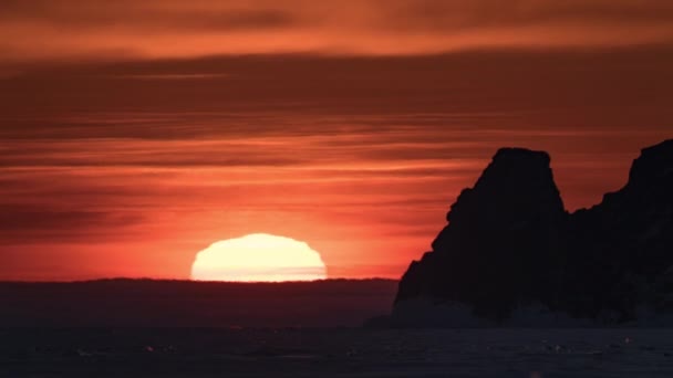 Ανατολή ηλίου με τεράστιο ήλιο και λίμνη θάλασσα και βράχο λόφο βουνό time lapse. Κόκκινη και μαύρη αυγή. Δραματική — Αρχείο Βίντεο