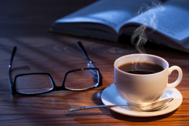Fincan kahve, kitap ve gözlük