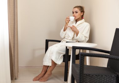 Bir fincan kahve içen bir kadın.