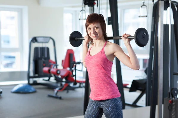 Vrouw met barbell op de sportschool — Stockfoto