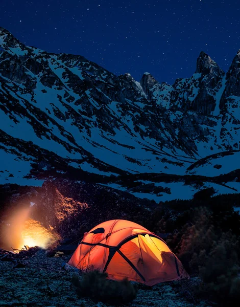 Red tent against snow mountains