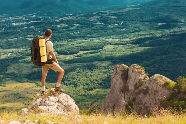 Backpacker stoi na skale i patrząc na duże doliny — Zdjęcie stockowe