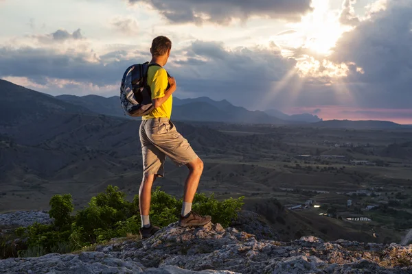 Wanderer mit Rucksack steht auf einem Felsen — Stockfoto