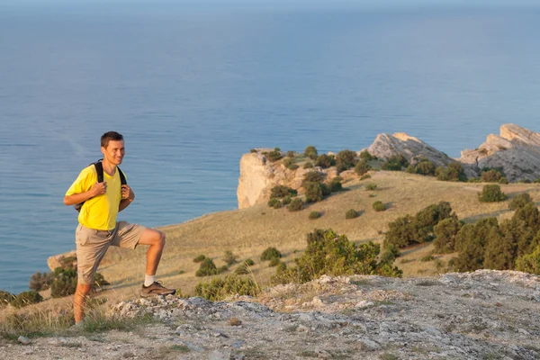Uzun yürüyüşe çıkan kimse sırt çantası konumu bir kaya üzerinde olan 