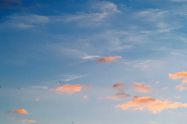 Mavi gökyüzünde sonbahar kırmızı gri bulutlar 