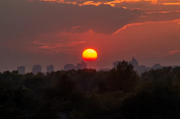 日落时的太阳, 城市上空有云 — 图库照片