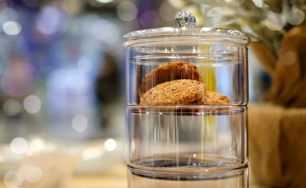 Пекарские овсяные печенья в стеклянную банку упаковки на размытом боке фоне с копировальным местом Стоковое Изображение