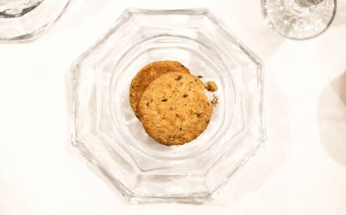 Beyaz arka planda cam tabakta fırın yulaf kurabiyeleri, üst manzara.