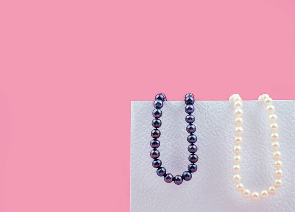 Wenige Perlen Hängen Auf Einer Weißen Schachtel Auf Rosa Hintergrund — Stockfoto