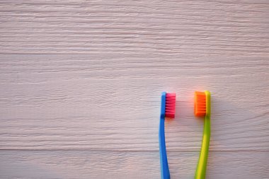 Ahşap arka planda iki plastik diş fırçası. Boşluğu kopyala