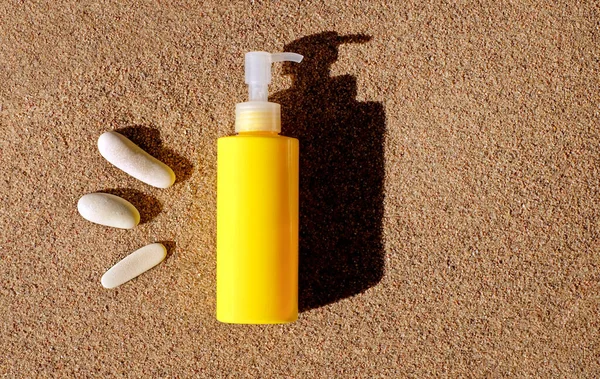 Бутылка солнцезащитного крема на песке на пляже, макет для защиты от солнца, копировальное пространство Стоковое Изображение