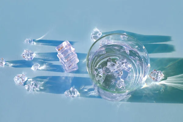 Vaso de agua con hielo sobre fondo azul, vista superior — Foto de Stock