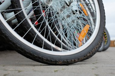 Wheels of bcycles parking for rent close-up on street background