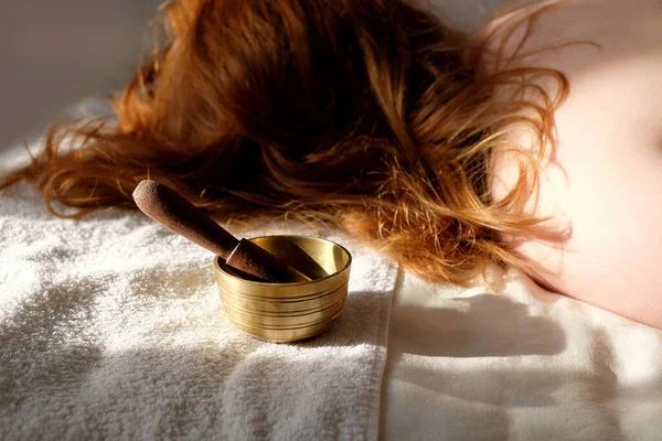 Taça de canto e mulher no fundo no salão de spa. Conceito de terapia sonora e cuidados com o corpo — Fotografia de Stock