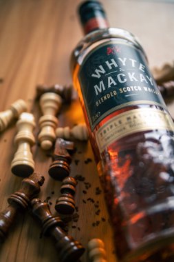 Satranç taşları ahşap bir masaya saçılmış.