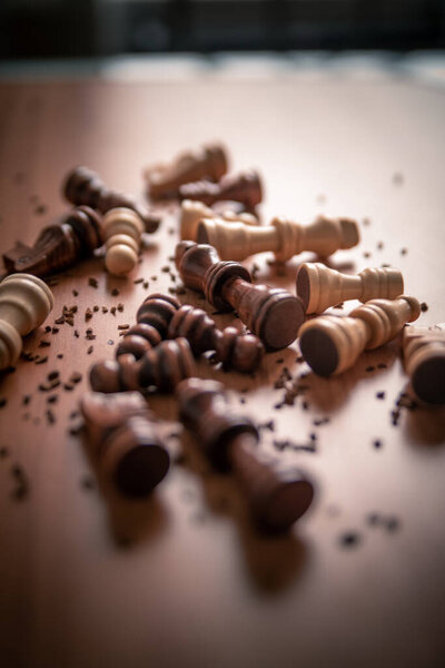 Шахматные фигуры, разбросанные на деревянном столе