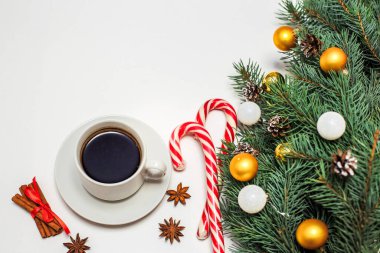 Masada bir fincan kahve, süslemeler, köknar dalları, şeker ve tarçın olan bir Noel düzeni. Yeni Yıl