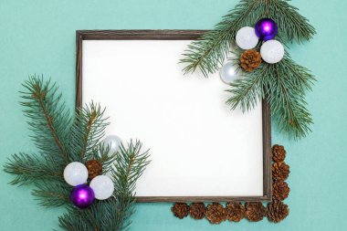 Köknar dalları, kozalaklar, Noel oyuncakları ve süslemelerden oluşan Noel kompozisyonu. Metin için boşluğu olan Noel çerçevesi