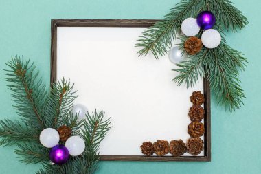 Köknar dalları, kozalaklar, Noel oyuncakları ve süslemelerden oluşan Noel kompozisyonu. Metin için boşluğu olan Noel çerçevesi