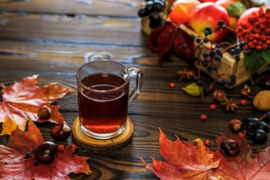Bir fincan çay, sonbahar yaprakları, meyveler ve fındıklı sonbahar kompozisyonu