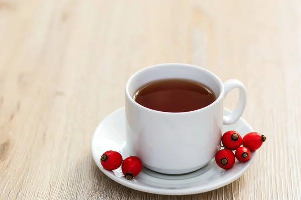Uma Xícara Branca Chá Rosa Mosqueta Uma Superfície Madeira Lado — Fotografia de Stock