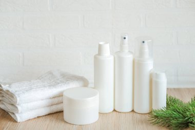 Masada beyaz şişe ve konteynırlar bulunan spa kompozisyonu, yeni yılın spa seti