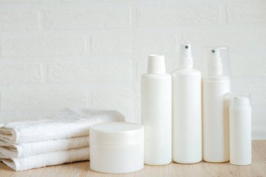 Masada beyaz havlular, şişeler ve kaplar, spa seti.