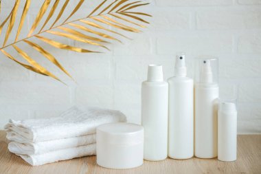 Masada beyaz havlular, şişeler ve kaplar, spa seti.