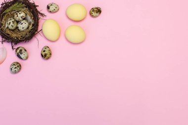 Paskalya kompozisyonu pembe arka planda boyalı yumurtalar ve boşluğun bir kopyası.