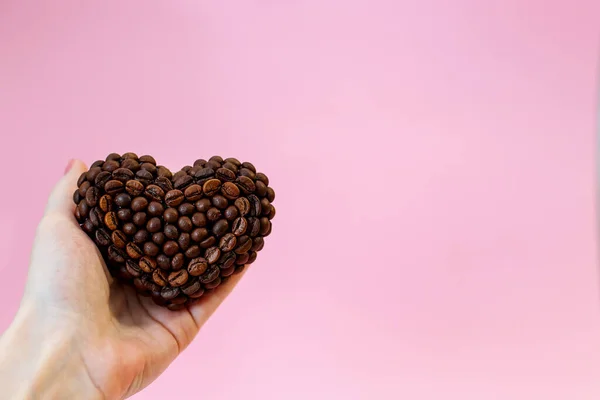 Καφέ Φασόλι Καρδιά Στο Χέρι Ροζ Φόντο — Φωτογραφία Αρχείου