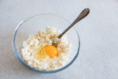 Masada bir kase süzme peynir ve tavuk yumurtası var.