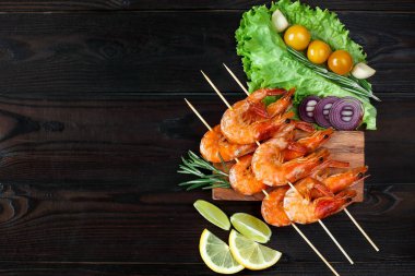 Ahşap tezgahta sebze ve otlarla ızgara karides. Restoran menüsü, Akdeniz mutfağı. Şişte ızgara karides.