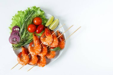 Sebze ve otlarla dolu bir tabakta ızgara karides. Şiş ızgara karides, restoran menüsü, Akdeniz mutfağı.