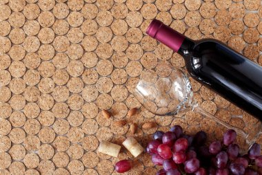 Bardakların üst görüntüsü ve bir şişe kırmızı şarap, mantar arka planda olgun üzümler, metin için yeri olan yatay konum