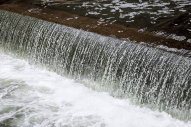 Geniş bir yapay şelaleye düşen temiz su manzarası