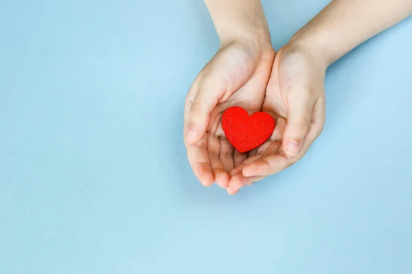 Κόκκινη Καρδιά Στα Χέρια Ενός Παιδιού Μπλε Φόντο Φιλανθρωπία Και — Φωτογραφία Αρχείου