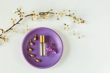 Mor bir büfede parfüm ve serum kapsülleri.